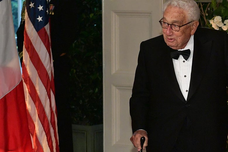 Henry Kissinger walking with a cane.